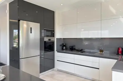 a kitchen with white cabinets and a stainless steel refrigerator at Ardian's home in Chania Town