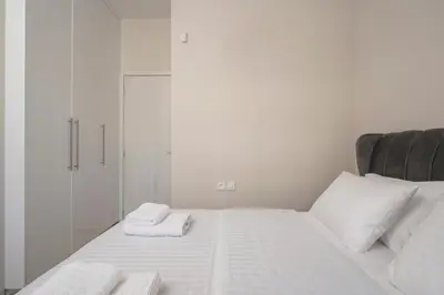 a white bed with two towels on top of it at Ardian's home in Chania Town