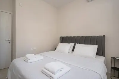 a bedroom with a white bed with towels on it at Ardian's home in Chania Town