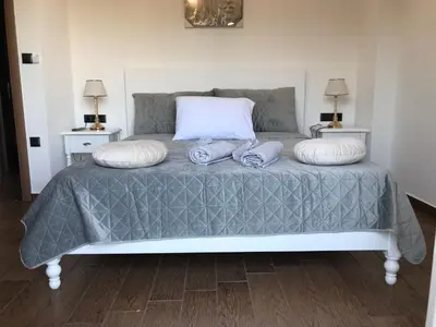 a bed with two pillows and two towels on it at Helen in Pírgos Psilonérou