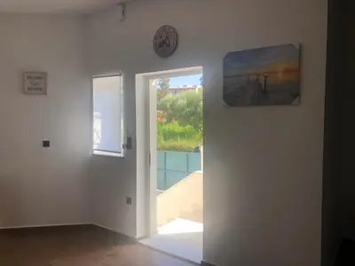a room with a door and a clock on the wall at Helen in Pírgos Psilonérou