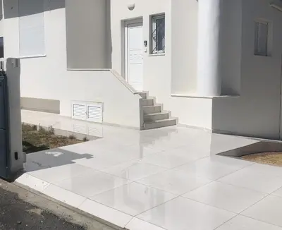 a white tile floor in front of a building at Helen in Pírgos Psilonérou