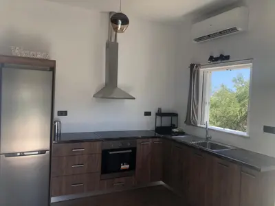 a kitchen with wooden cabinets and a sink and a window at Helen in Pírgos Psilonérou