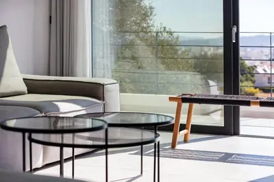 a living room with a couch and two glass tables at Ikon Living Chania in Chania Town