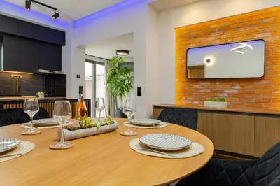 a dining room with a table and a tv at Noir Residence - Chic 2Br House Near Maleme Beach in Maleme