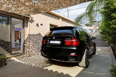 a black car parked outside of a house at Noir Residence - Chic 2Br House Near Maleme Beach in Maleme