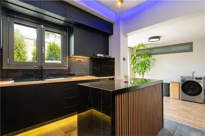 a kitchen with black cabinets and a black counter top at Noir Residence - Chic 2Br House Near Maleme Beach in Maleme