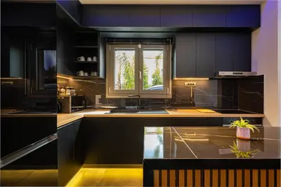 a kitchen with black cabinets and a window at Noir Residence - Chic 2Br House Near Maleme Beach in Maleme