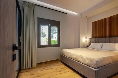 a bedroom with a bed and a window at Noir Residence - Chic 2Br House Near Maleme Beach in Maleme
