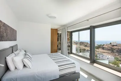 a bedroom with a bed and a large window at Villa Dóma in Sfakiá