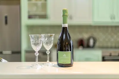 a bottle of wine and two glasses on a counter at Large Cozy House near the sea - Kolimvari Village - 6 Pax in Kolymvari