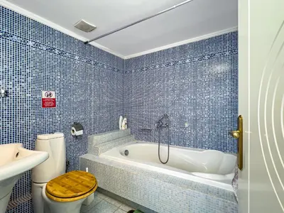 a blue tiled bathroom with a toilet and a tub at Large Cozy House near the sea - Kolimvari Village - 6 Pax in Kolymvari