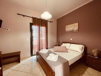 a bedroom with a bed and a large window at Girogiali Apt 3 in Kamára