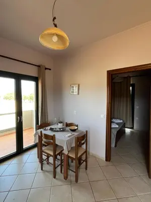 a dining room with a table and chairs and a window at Girogiali Apt 3 in Kamára