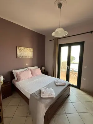 a bedroom with a large bed with pink pillows at Girogiali Apt 3 in Kamára