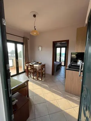 a kitchen and living room with a table and chairs at Girogiali Apt 3 in Kamára