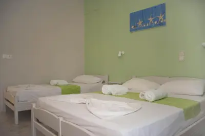 a group of three beds in a room at Nereides Hotel in Kolymvari