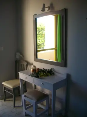 a dressing table in a room with a mirror at Nereides Hotel in Kolymvari