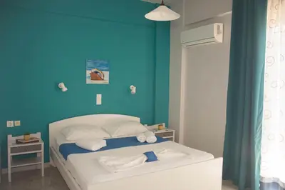 a blue bedroom with a bed with towels on it at Nereides Hotel in Kolymvari