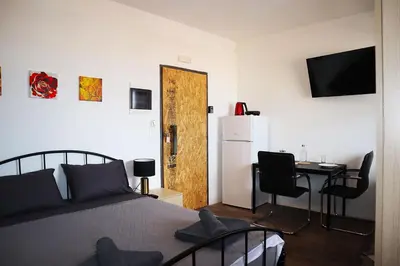 a bedroom with a bed and a desk and a refrigerator at Studio92 Chania in Chania Town