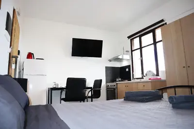 a bedroom with a bed and a kitchen with chairs at Studio92 Chania in Chania Town