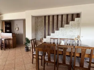 a dining room with a table and a staircase at Villa Metapothia Gavalochori Crete in Gavalochori