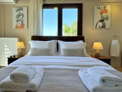 a bedroom with a large bed with towels on it at Villa Metapothia Gavalochori Crete in Gavalochori