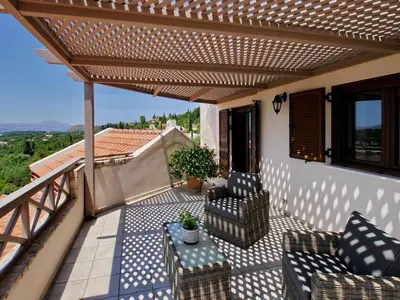 a patio with chairs and a table on a balcony at Villa Metapothia Gavalochori Crete in Gavalochori
