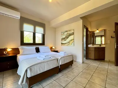 a bedroom with a bed and a bathroom at Villa Metapothia Gavalochori Crete in Gavalochori