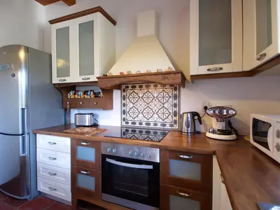 a kitchen with a stove top oven next to a refrigerator at Villa Amvrosia Nr Kalives Crete in Arménoi