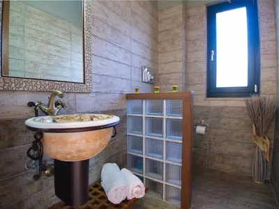a bathroom with a large sink and a window at Villa Amvrosia Nr Kalives Crete in Arménoi