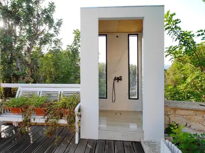 a glass door opens to a deck with plants at Villa Amvrosia Nr Kalives Crete in Arménoi
