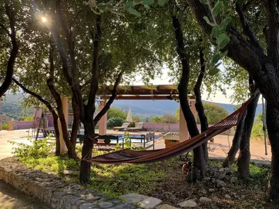 a hammock hanging between trees in a park at Villa Galania Armeni Crete in Arménoi