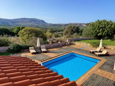 a swimming pool in a patio with chairs at Villa Galania Armeni Crete in Arménoi