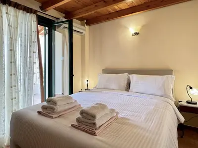 a bedroom with a white bed with towels on it at Villa Artemis Vryses Crete in Alikampos