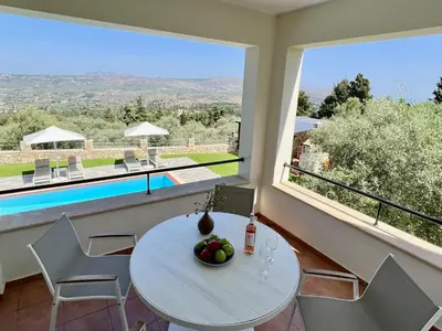 a dining room with a table and a large window at Villa Avra Vrisses Crete in Alikampos
