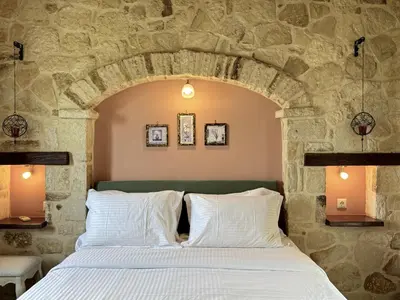 a bed in a room with a stone wall at Villa Avra Vrisses Crete in Alikampos