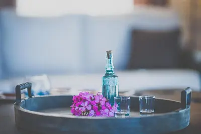 a bottle and two glasses on a table with flowers at Villa Olivia with Pool Vrises Crete in Alikampos