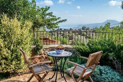 a patio with two chairs and a table in a garden at Villa Vigla in Samonás