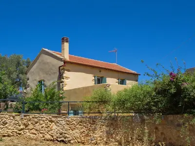 a house with a stone wall in front of it at Villa Vigla in Samonás