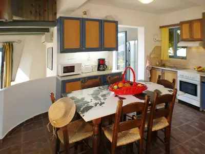 a kitchen with a table with a bowl of fruit on it at Villa Clio with Pool Stalos Crete in Stalos