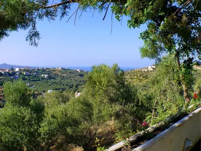 a view of the ocean from a hill with trees at Villa Clio with Pool Stalos Crete in Stalos