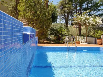 a swimming pool with a blue tile wall next to at Villa Clio with Pool Stalos Crete in Stalos