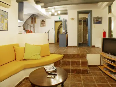 a living room with a yellow couch and a table at Villa Clio with Pool Stalos Crete in Stalos