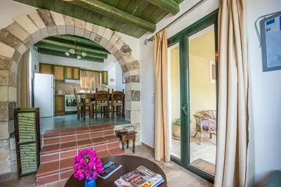 a living room with an archway and a kitchen at Villa Panos in Stalos in Stalos