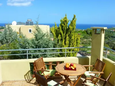 a table with a bowl of fruit on a balcony at Villa Panos in Stalos in Stalos