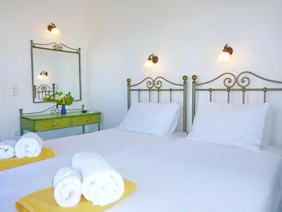 a bedroom with two beds and a mirror at Villa Panos in Stalos in Stalos