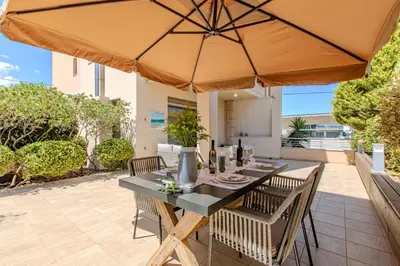 a dining table with an umbrella on a patio at Conte Marino Apartment in Chania Town