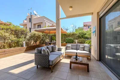 a patio with two couches and an umbrella at Conte Marino Apartment in Chania Town