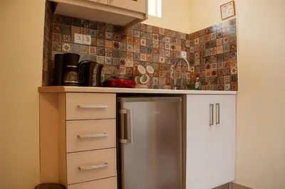 a small kitchen with a stainless steel refrigerator at Viva Elafonisi - Studios or Apartment, 10min to Elafonissi in Plokamianá